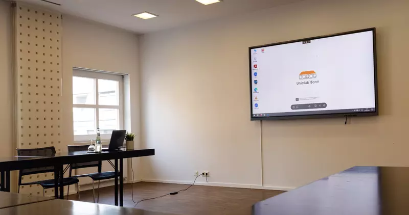 Martini-Raum gut beleuchtet mit TFT-Touchscreen, Tageslicht, Tischen in U-Form und Stühlen